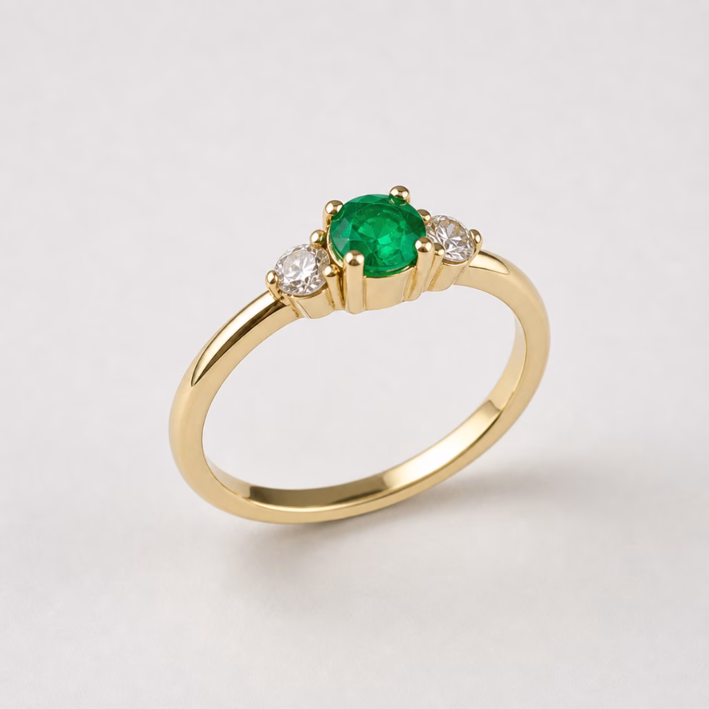 Emerald and diamond ring in 14K yellow gold with a delicate band and round centre stone