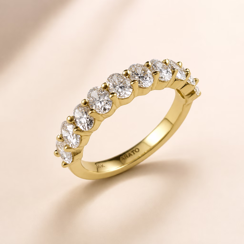 Yellow gold ring with large round diamonds in prong settings on a soft neutral background.